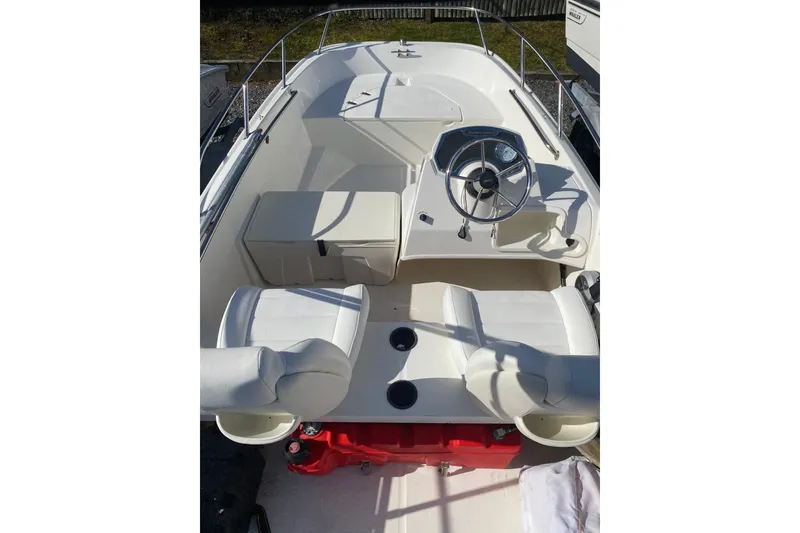 Slide: The Image of 2018 Boston Whaler 150 Super Sport boat interior with steering wheel and seating. - 5