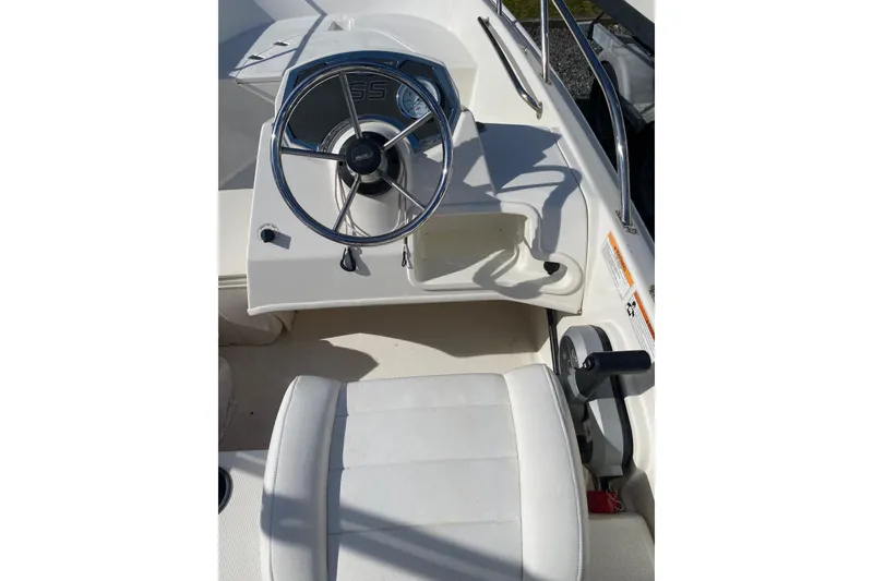 Slide: The Image of 2018 Boston Whaler 150 Super Sport boat interior with steering wheel and seat. - 6