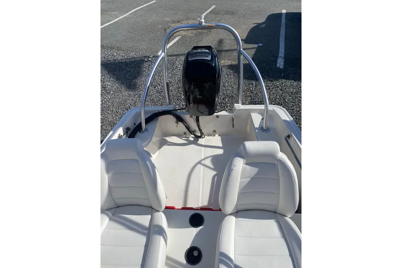 Slide: The Image of 2018 Boston Whaler 150 Super Sport boat interior with white seating and motor. - 7