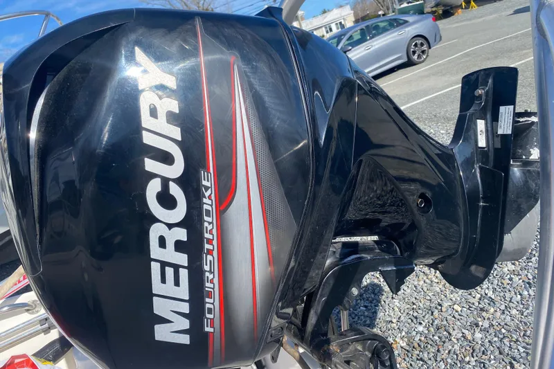 Slide: The Image of Mercury FourStroke engine on 2018 Boston Whaler 150 Super Sport boat, parked outdoors. - 9