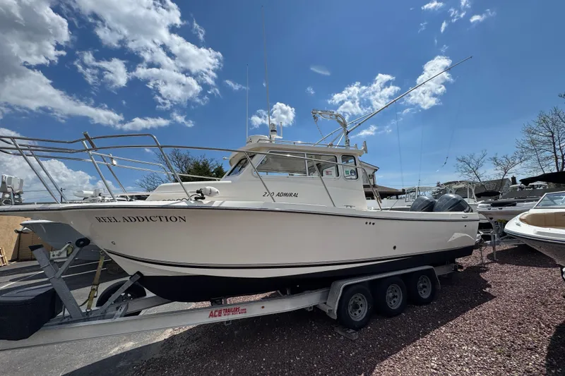 The Image of 2016 Defiance Admiral 270 EX boat on trailer under blue sky. - 1