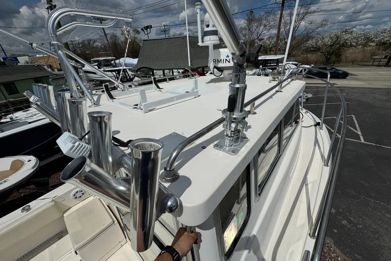 Slide: The Image of 2016 Defiance Admiral 270 EX boat with fishing rod holders and rooftop equipment. - 26