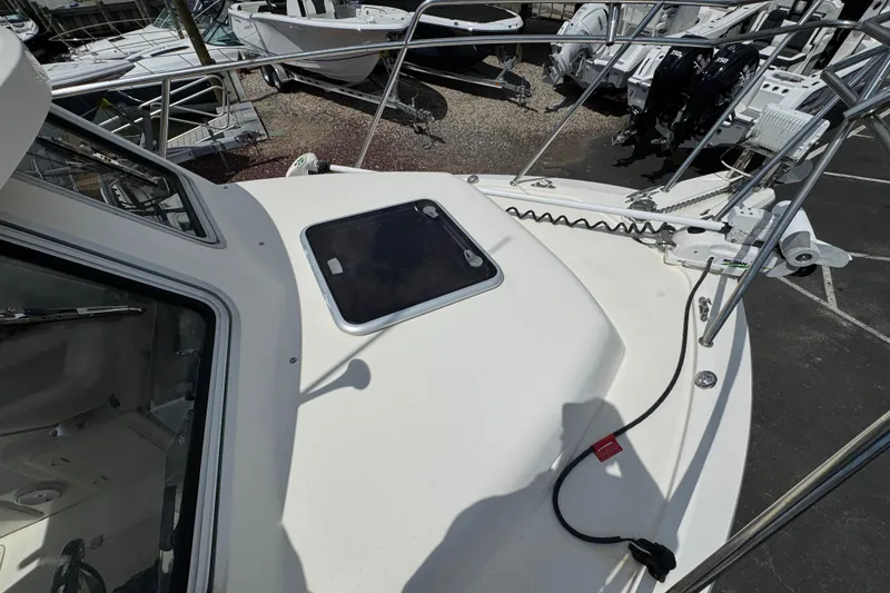 Slide: The Image of 2016 Defiance Admiral 270 EX boat deck with hatch and railing, docked among other boats. - 28