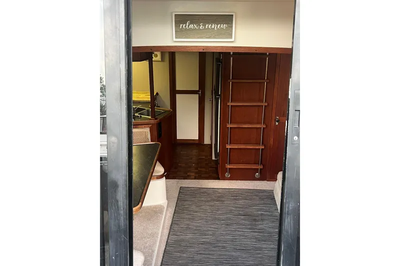 Slide: The Image of Interior view of 1986 Carver 3297 Mariner boat, featuring cozy cabin and wooden ladder. - 2