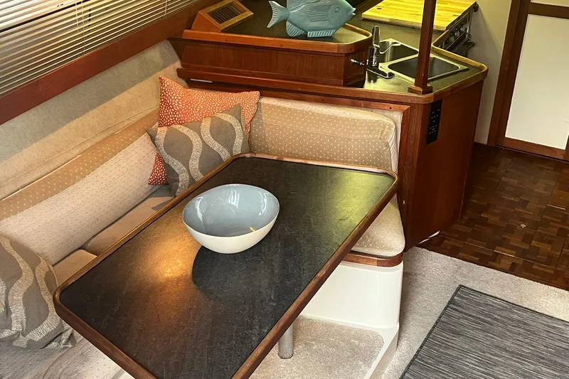 Slide: The Image of Interior of 1986 Carver 3297 Mariner yacht with cozy seating and dining area. - 3
