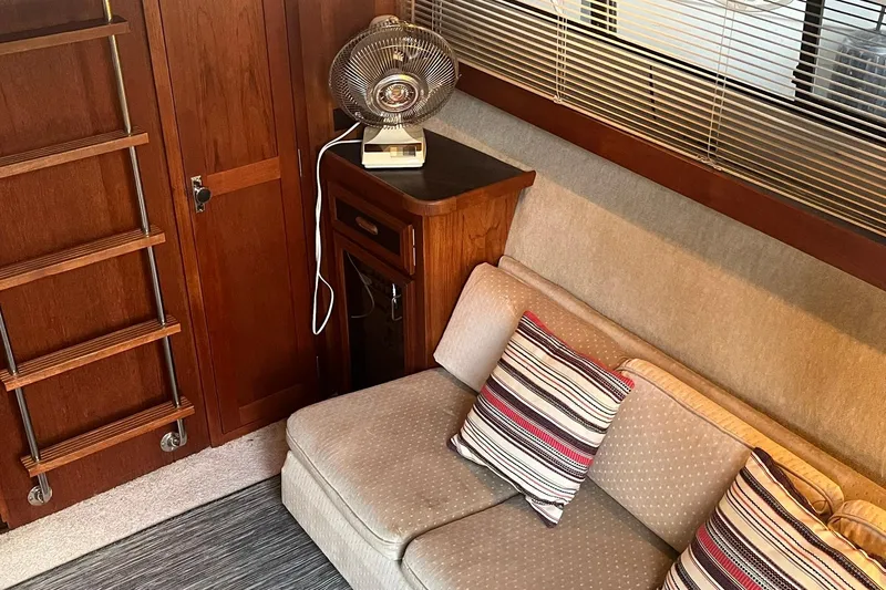 Slide: The Image of Interior of 1986 Carver 3297 Mariner with cozy seating and striped pillows. - 4
