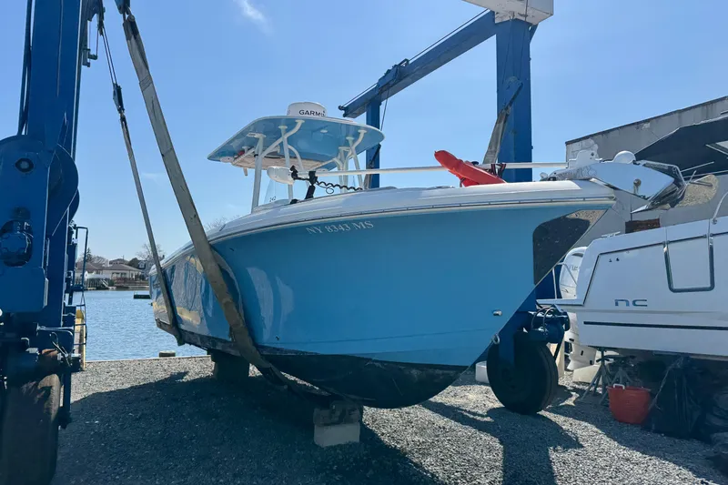 The Image of 2022 Sailfish 242 CC boat in dry dock, blue hull, ready for launch. - 1