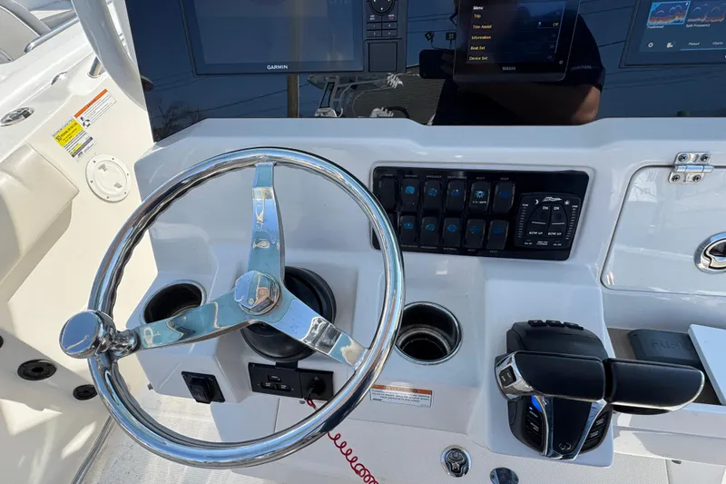 Slide: The Image of Steering console of 2022 Sailfish 242 CC boat with controls and display screens. - 12
