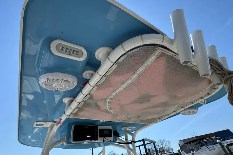 Slide: The Image of 2022 Sailfish 242 CC boat's blue T-top with speakers and rod holders. - 16