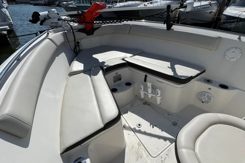 Slide: The Image of Interior view of 2022 Sailfish 242 CC boat with cushioned seating and fishing rod holders. - 18