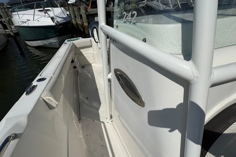 Slide: The Image of 2022 Sailfish 242 CC boat docked, showcasing sleek white interior and sturdy railings. - 22