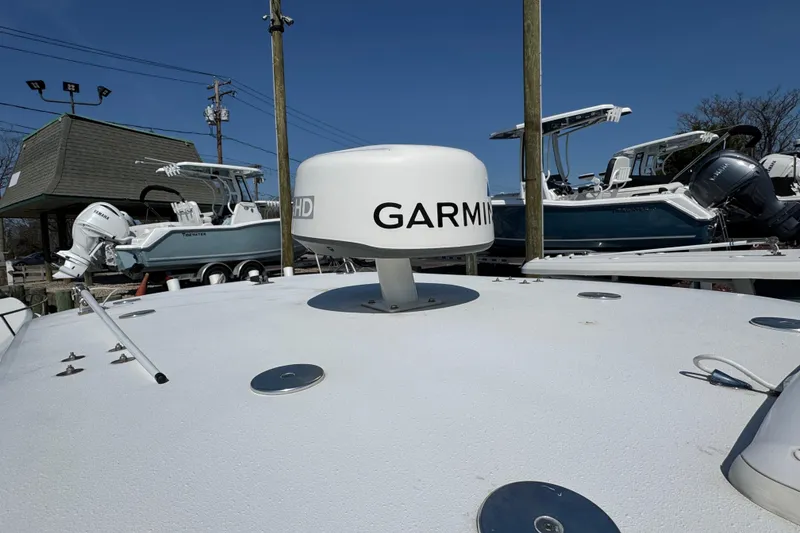 Slide: The Image of 2022 Sailfish 242 CC boat with Garmin radar, docked alongside other boats. - 23