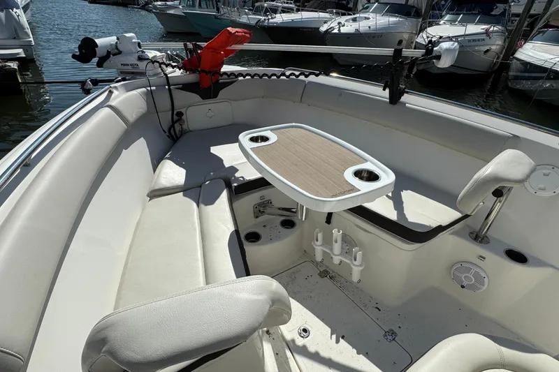 Slide: The Image of 2022 Sailfish 242 CC boat interior with seating and table, docked at marina. - 24