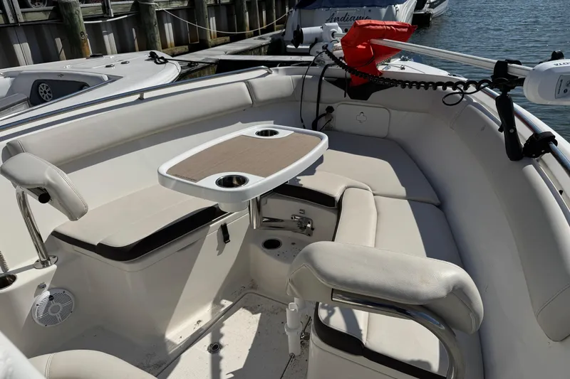 Slide: The Image of Interior of 2022 Sailfish 242 CC boat with seating and table, docked at marina. - 28