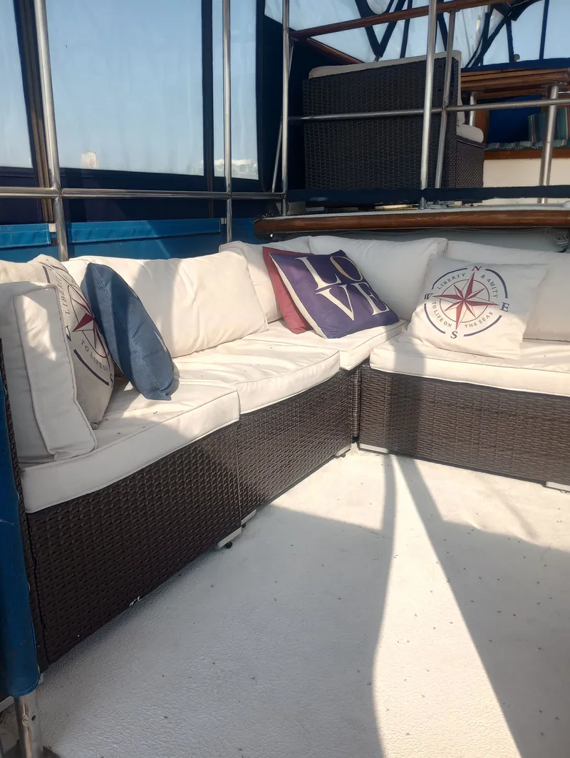 Slide: The Image of Marine Trading 44 Double Cabin 1981 with cozy seating area and decorative pillows. - 11