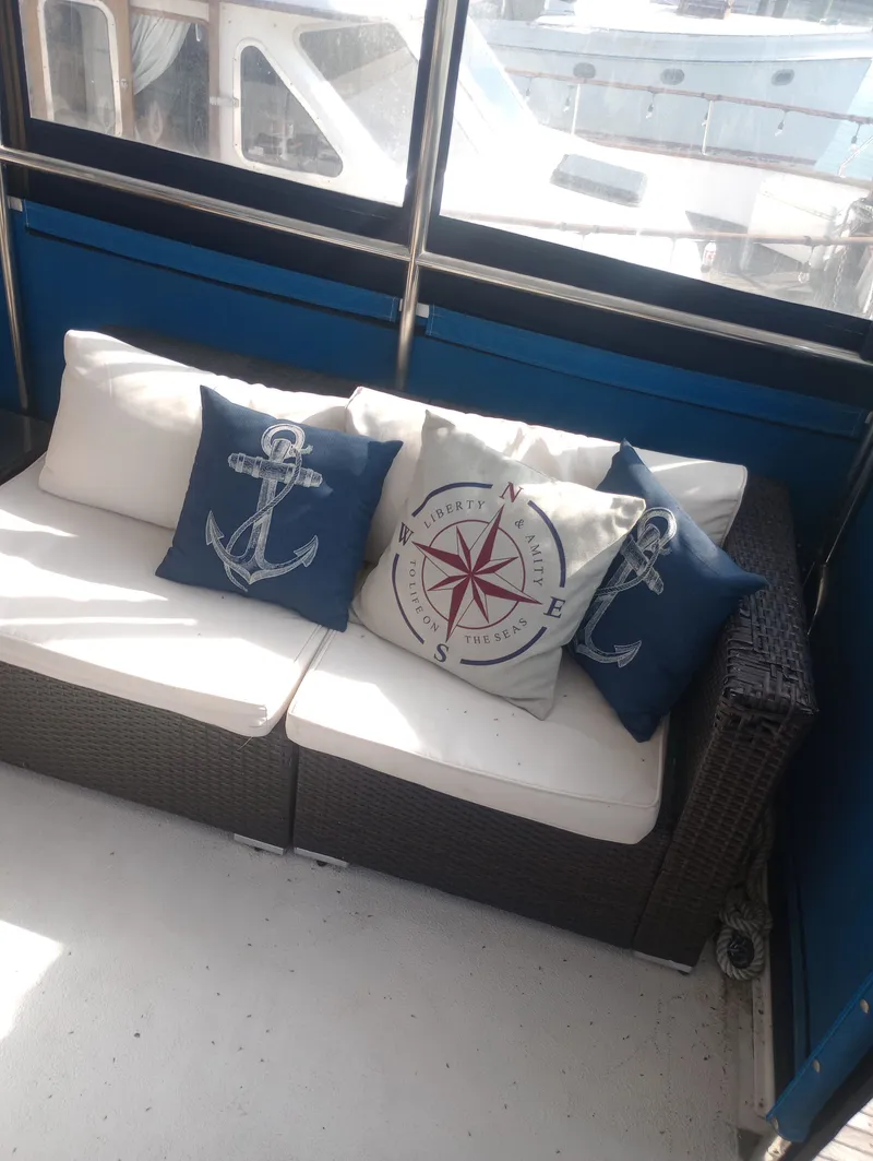 Slide: The Image of Marine Trading 44 Double Cabin 1981 with nautical-themed pillows on sofa. - 12
