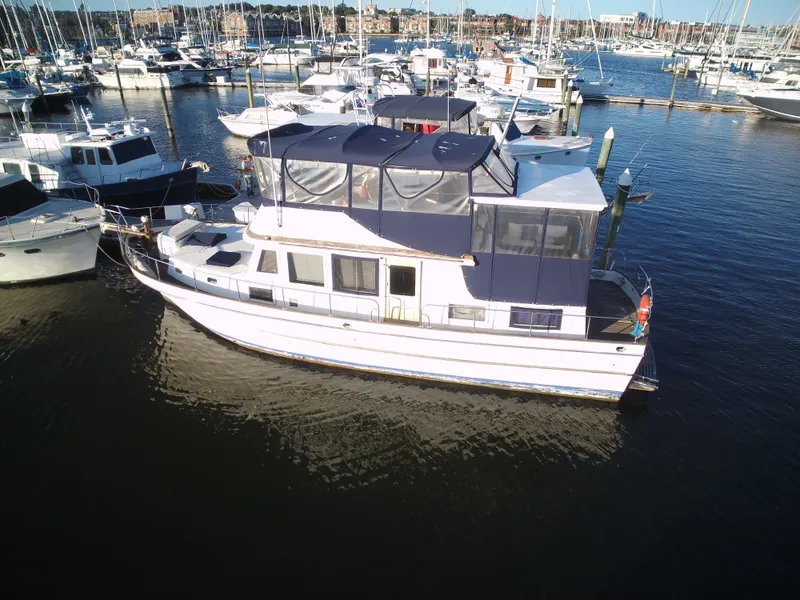 Slide: The Image of 1981 Marine Trader 44 Double Cabin docked in a marina, surrounded by other boats. - 3
