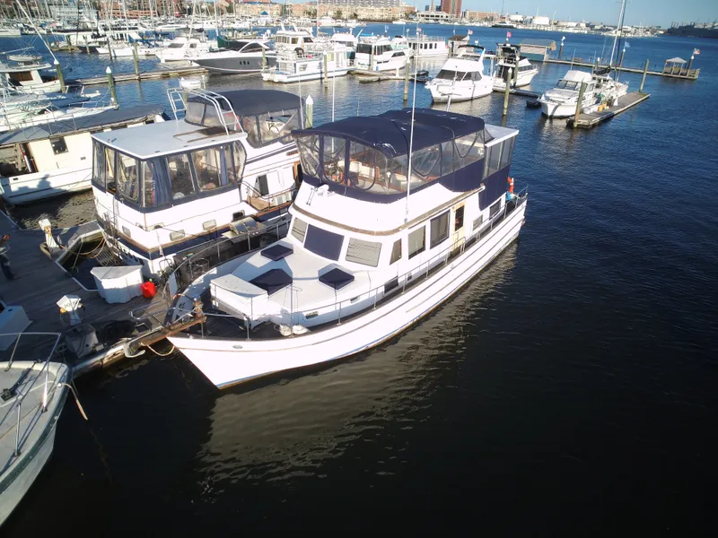 Slide: The Image of 1981 Marine Trader 44 Double Cabin docked in a marina, surrounded by other boats. - 2