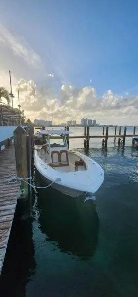 Slide: The Image of 2013 Scout 275 LXF boat docked at a marina under a clear sky. - 13