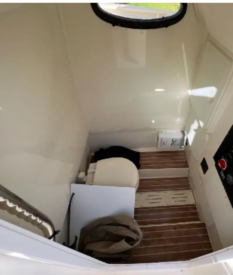 Slide: The Image of Interior of 2013 Scout 275 LXF boat with wooden flooring and compact toilet. - 8