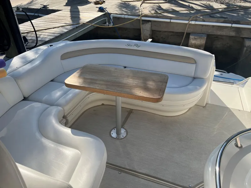 Slide: The Image of 2008 Sea Ray 340 Sundancer boat interior with white seating and wooden table. - 11