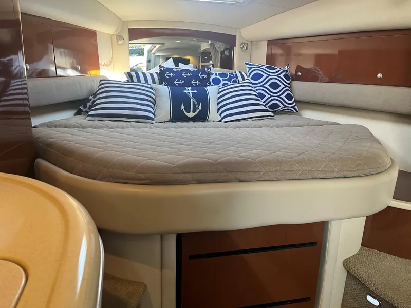 Slide: The Image of Interior of 2008 Sea Ray 340 Sundancer with nautical-themed pillows and cozy bed. - 16