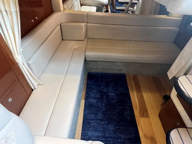 Slide: The Image of Interior of 2008 Sea Ray 340 Sundancer with white leather seating and blue rug. - 21