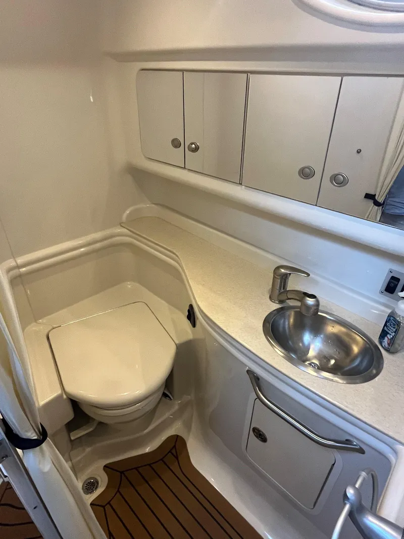 Slide: The Image of 2008 Sea Ray 340 Sundancer bathroom with sink, toilet, and storage cabinets. - 24