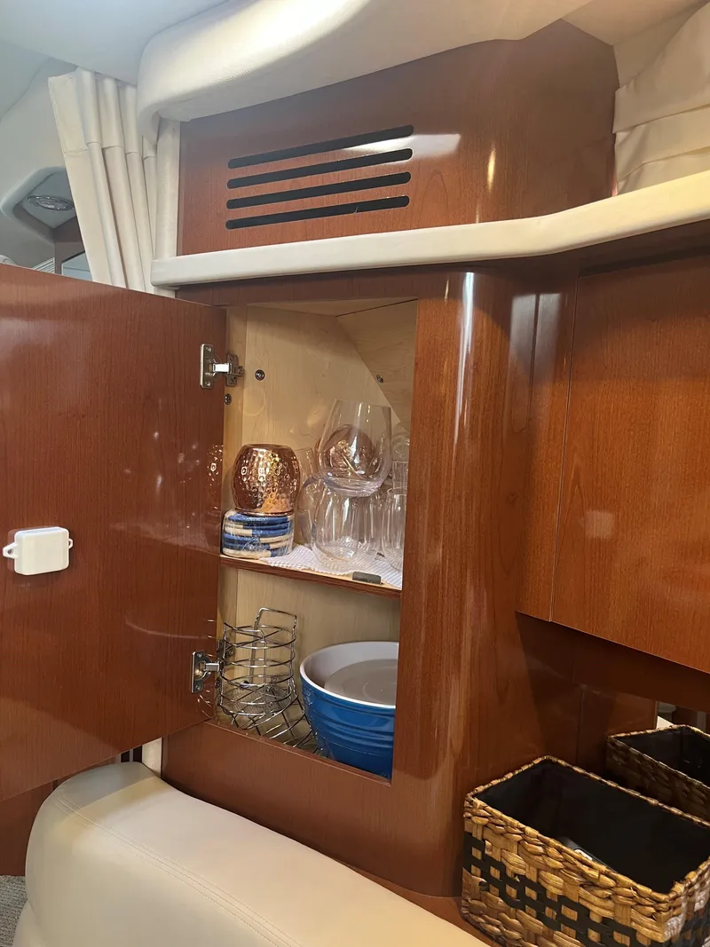 Slide: The Image of Interior of 2008 Sea Ray 340 Sundancer with open cabinet displaying glassware and bowls. - 26