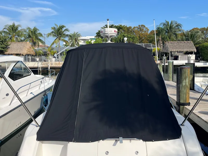 Slide: The Image of 2008 Sea Ray 340 Sundancer with black cover docked near palm trees. - 3