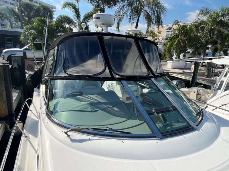 Slide: The Image of 2008 Sea Ray 340 Sundancer boat docked, surrounded by palm trees and clear skies. - 4