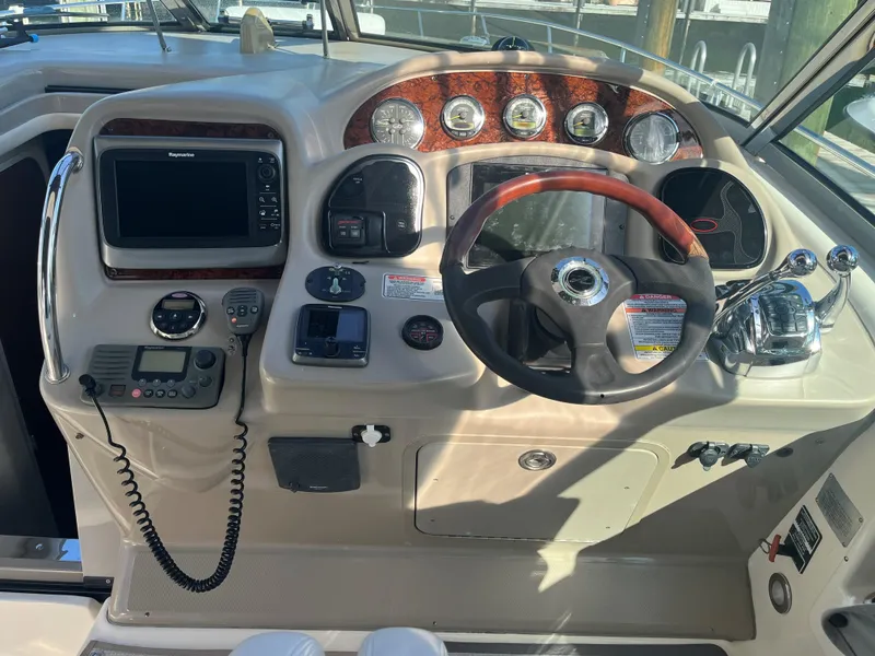 Slide: The Image of 2008 Sea Ray 340 Sundancer helm with steering wheel and navigation controls. - 9