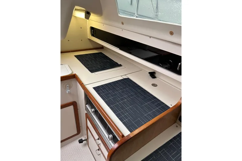 Slide: The Image of Interior of a 1994 Catalina 270 sailboat galley with wooden trim and modern amenities. - 13