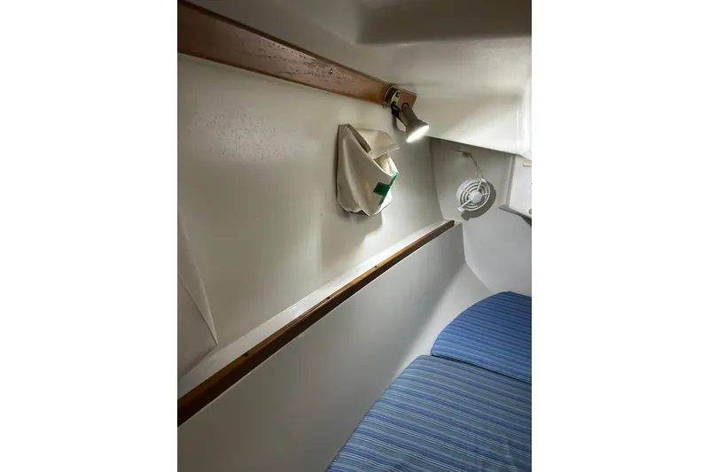 Slide: The Image of Interior cabin of a 1994 Catalina 270 sailboat with blue-striped bedding. - 16