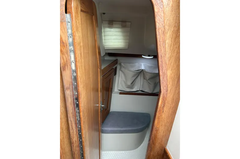 Slide: The Image of Interior cabin view of a 1994 Catalina 270 sailboat with wooden door and storage. - 17