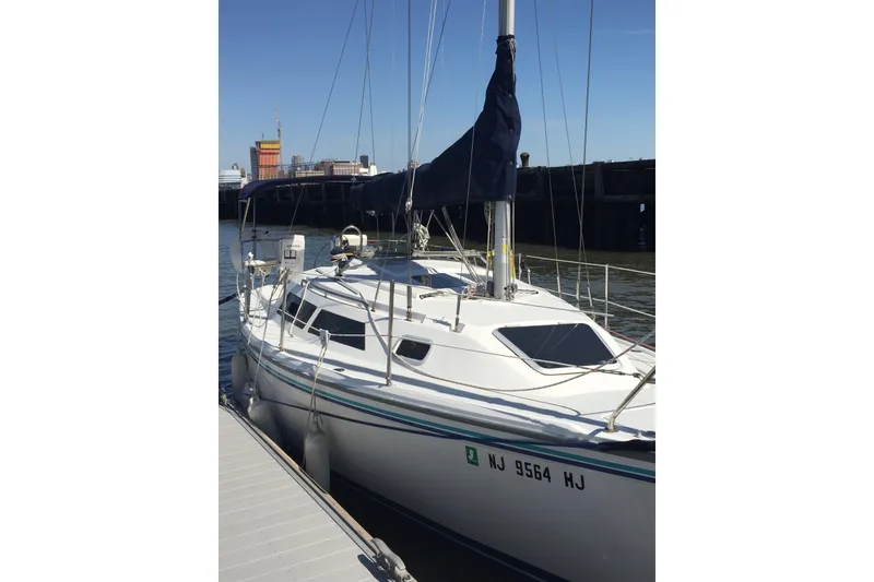 Slide: The Image of 1994 Catalina 270 sailboat docked at marina, clear sky background. - 2