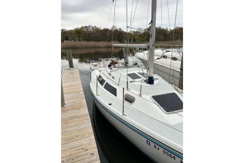 Slide: The Image of 1994 Catalina 270 sailboat docked at a marina, showcasing sleek design and white exterior. - 6