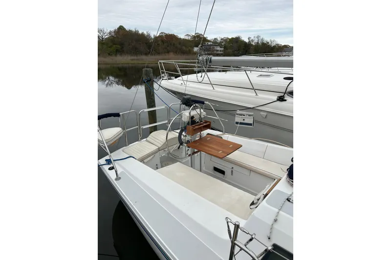 Slide: The Image of 1994 Catalina 270 sailboat docked, featuring a spacious cockpit and wooden table. - 9