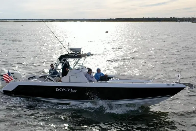 The Image of 2008 Donzi 35 ZR Open boat cruising on a sunlit waterway. - 1