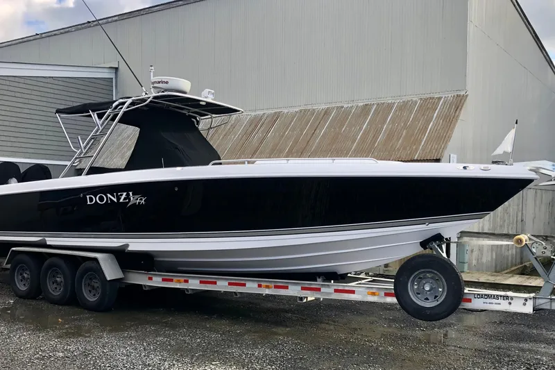 Slide: The Image of 2008 Donzi 35 ZR Open boat on trailer, black and white design, parked outdoors. - 11