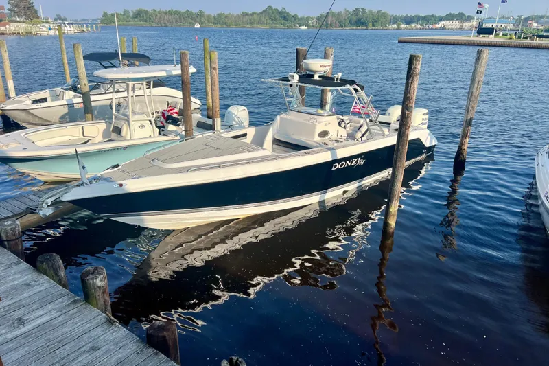 Slide: The Image of 2008 Donzi 35 ZR Open boat docked at a marina, surrounded by calm water. - 5