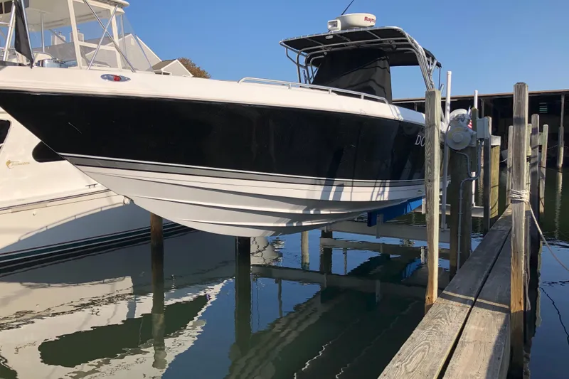 Slide: The Image of 2008 Donzi 35 ZR Open boat docked, featuring sleek black and white design. - 6