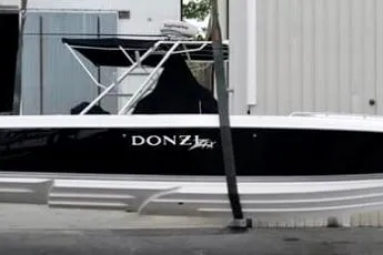 Slide: The Image of 2008 Donzi 35 ZR Open boat with black hull and white accents docked. - 8