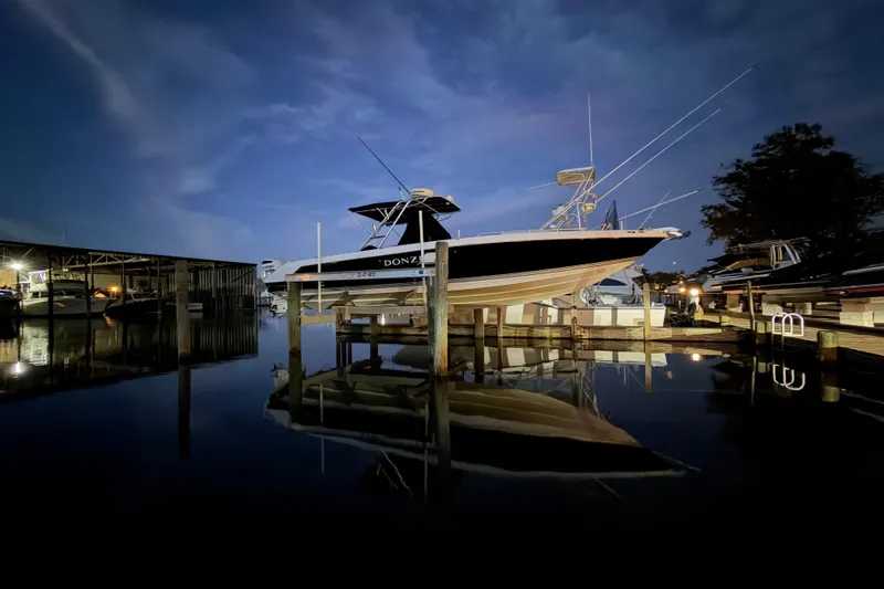 Slide: The Image of 2008 Donzi 35 ZR Open boat docked at night, reflecting on calm water. - 9