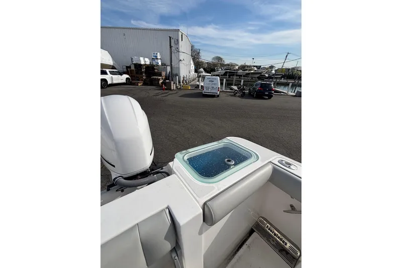 Slide: The Image of 2017 Everglades 255 Center Console boat with livewell, parked near a marina. - 17