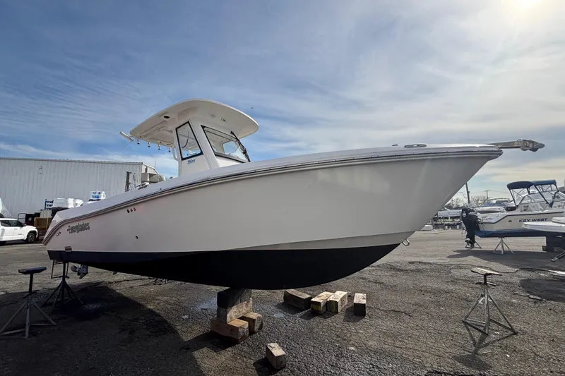 Slide: The Image of 2017 Everglades 255 Center Console boat on display in a marina under a clear sky. - 3