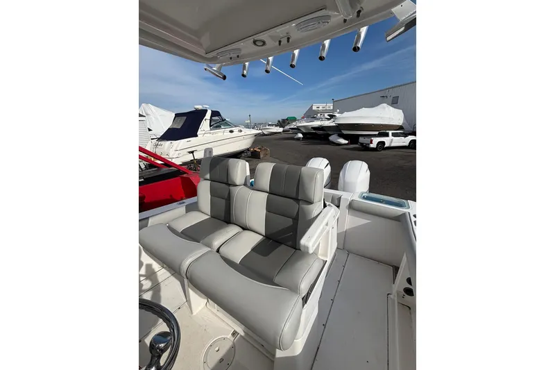 Slide: The Image of 2017 Everglades 255 Center Console boat interior with cushioned seating and rod holders. - 9