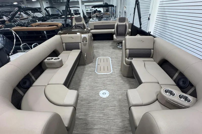 Slide: The Image of 2024 Bennington 24 L Swingback pontoon boat interior with beige seating and cup holders. - 12