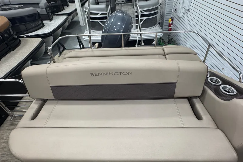 Slide: The Image of 2024 Bennington 24 L Swingback boat interior with beige seating and cup holders. - 20