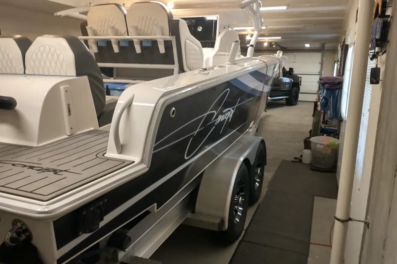 Slide: The Image of 2019 Concept 30' Open Deck boat in a garage, featuring sleek design and dual axles. - 8